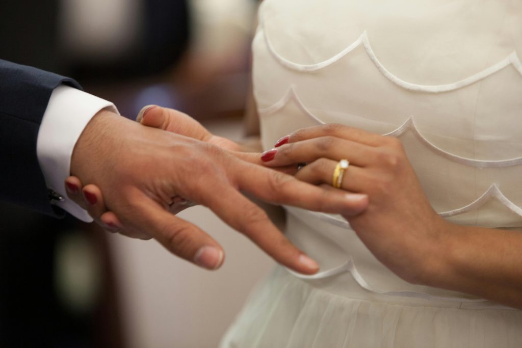 Close-up of a bride and groom exchanging rings during their wedding ceremony, symbolizing love and unity.